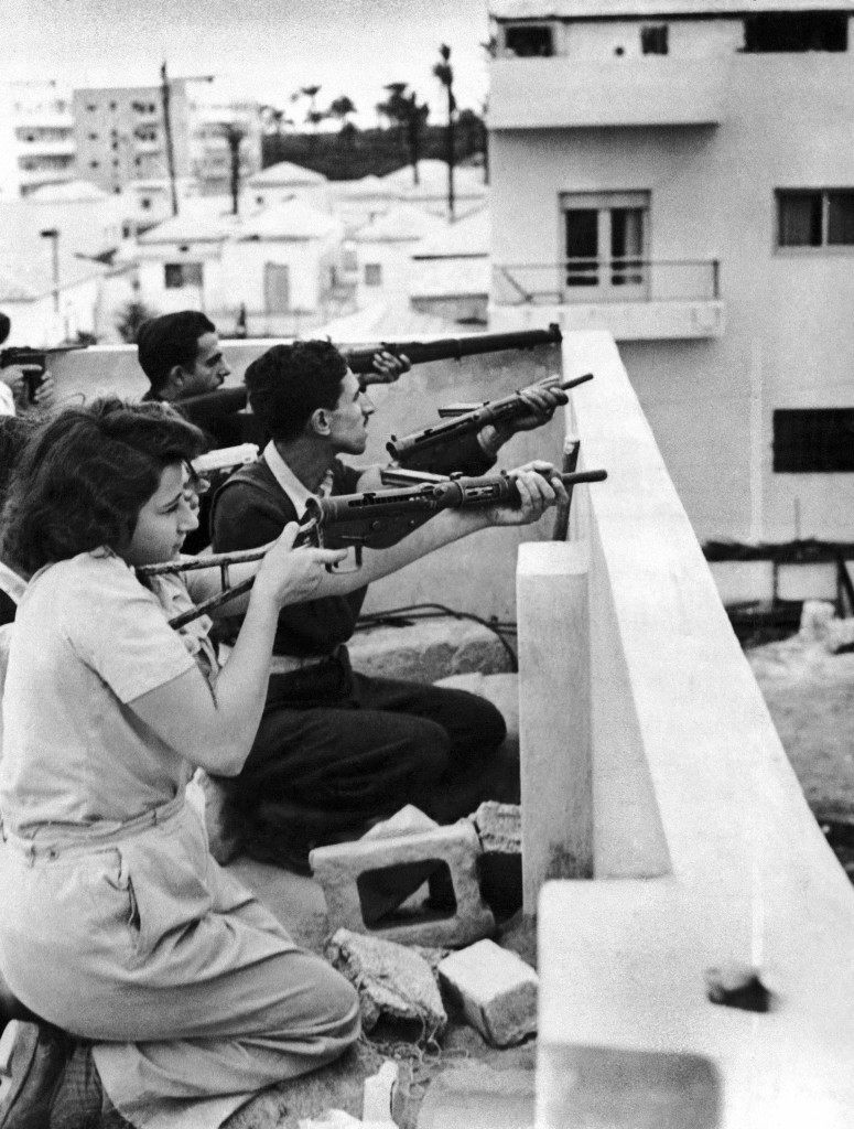Members of the Jewish right-wing underground organization Irgun Zvai Leumi (National Military Organization in the Land of Israel) are armed with rifles, revolvers and automatic weapons as they take position on the rooftop of a Jewish house in case of Arab attack on the Jaffa - Tel Aviv border in the Manshiah Jewish quarter in Tel Aviv, Israel, on December 27, 1947. The Zionist guerrilla force began an armed revolt against British rule in Palestine. (AP Photo/James Pringle) Ref #: PA.10005962  Date: 27/12/1947
