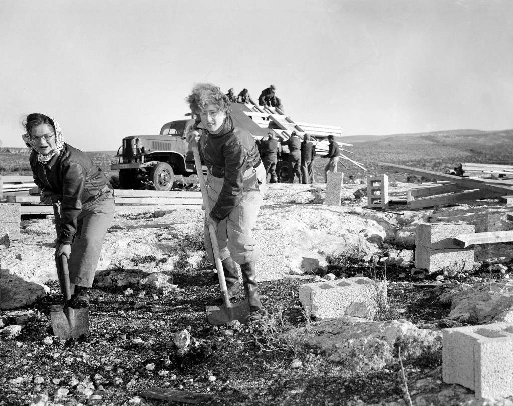 Miriam Wiess, left, of Glasgow, Scotland, and Leah Cohen, of Leeds, help clear ground for the erection of a building at the site of the new Israeli kibbutz settlement in Yazur, in western Galilee, Israel, Feb. 13, 1949. (AP Photo) Ref #: PA.2823960  Date: 13/02/1949