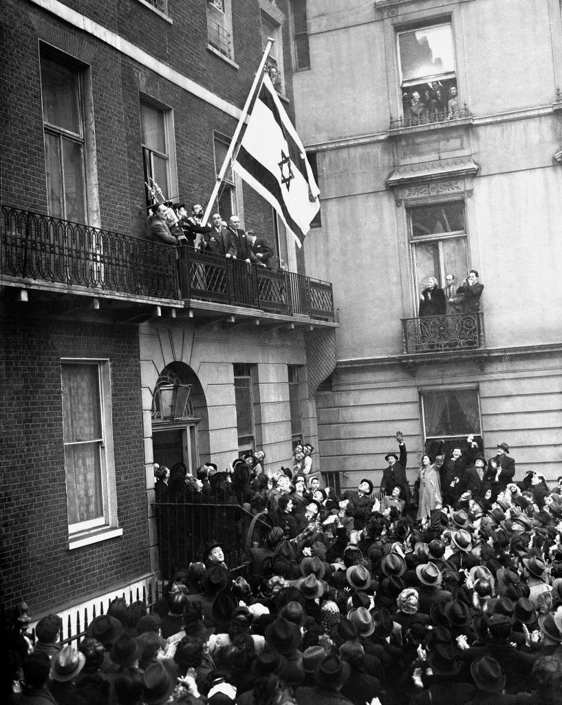 The flag of the Israeli Government, proclaiming the recognition of the government by Britain, was hoisted at the offices of the Israeli Government in Manchester Square, London, by 17 year old Ruth Liebstadter, the youngest member of staff. Ref #: PA.5481788  Date: 31/01/1949