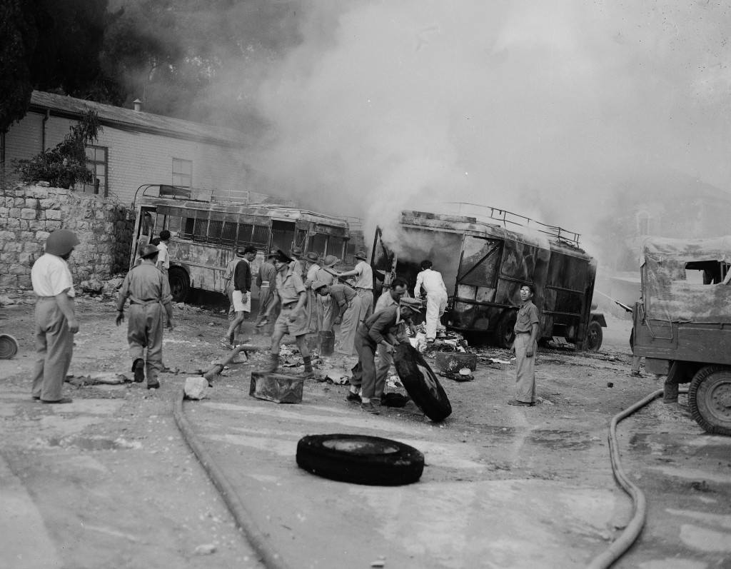 Jewish firefighters engage in salvage operations as smoke still rises from two buses set aflame when a parking lot along Jaffa Road in Jerusalem was struck by Arab incendiary mortar shells, June 12, 1948. The parking lot was hit during one of the daily shellings of the new section of the city by the Arab legion. (AP Photo/Tom Fitzsimmons) Ref #: PA.5736812  Date: 12/06/1948