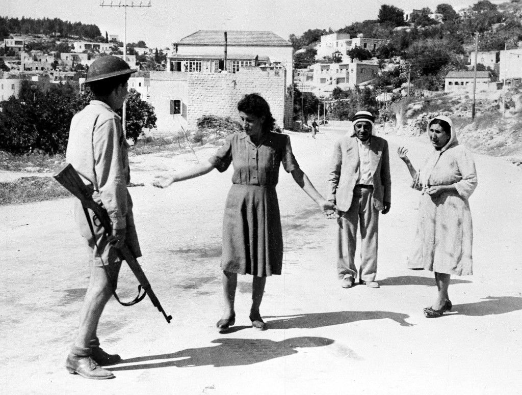 An Israeli soldier, armed with a rifle, stop some arabs in a street in Nazareth, Palestine, July 17, 1948, as they are travelling after the allotted curfew time. Israeli forces had occupied the town earlier that day. (AP Photo) Ref #: PA.5736836  Date: 17/07/1948
