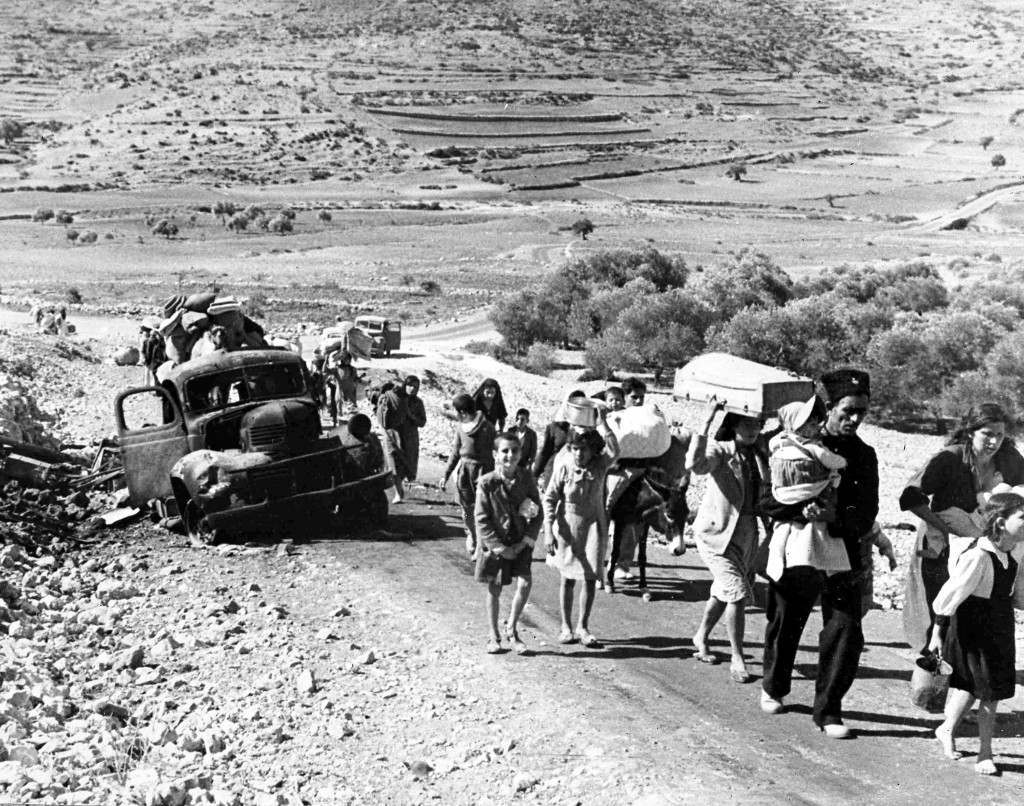 A group of struggling Arab refugees walk along the dusty road from Jerusalem to Lebanon, carrying their meagre belongings with them, Nov. 9, 1948. The arabs have been driven from their homes by Jewish attacks in Galilee. (AP Photo/Pringle) Ref #: PA.5737111  Date: 09/11/1948