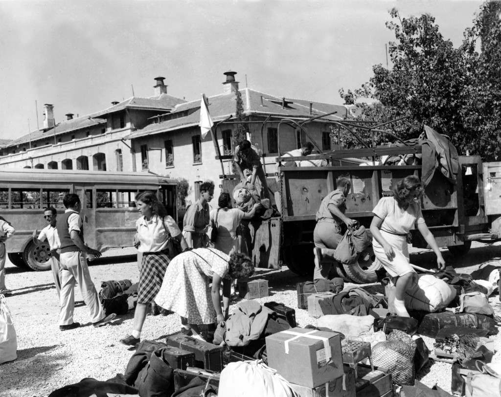 Jewish nurses stranded for three months in the neutral area on Mount Scopus, which is in Arab-held territory, sort out their luggage after being brought back safely to Jerusalem in armored buses of a United Nations convoy on Oct. 8, 1948 in the Arab-Israeli War. Israeli police, also stranded in the demilitarized zone, were brought back with them and the Arabs permitted police replacements to go to Mount Scopus. (AP Photo/James Pringle) Ref #: PA.5737255  Date: 08/10/1948