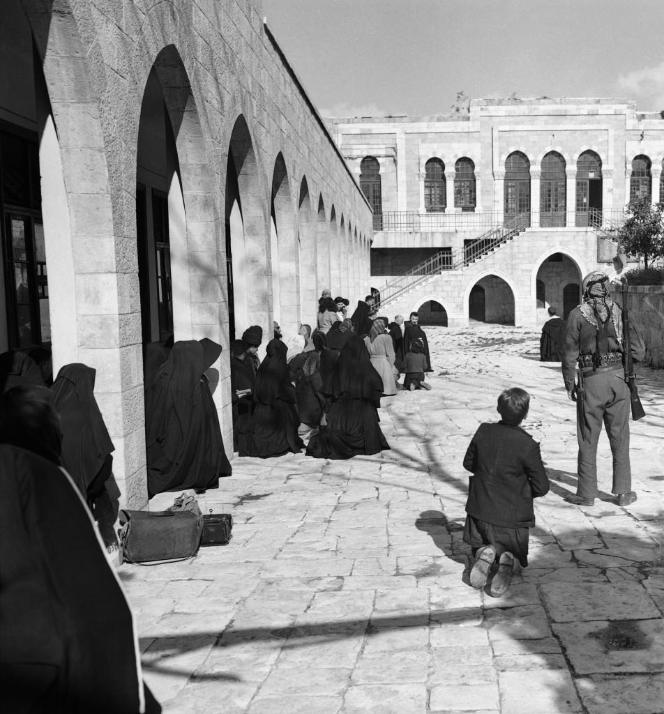 While an armed Arab (right) stands guard, Christian Pilgrims kneel in what is said to have been the court of Pontius Pilate in Jerusalem, scene of first station of the way of cross. The place where Pilate condemned Jesus to death had been a British Police Station but recently was abandoned because of Arab-Jewish strife. Now it is used as headquarters of Arab National Police, Friday, March 26, 1948 in Jerusalem observances of stations of cross which were repeated, March 26, Good Friday. (AP Photo) Ref #: PA.7380227  Date: 26/03/1948