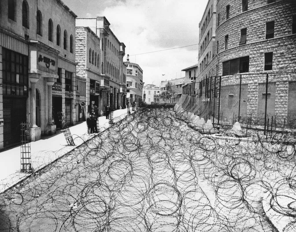 Barbed wire covers the entire roadway for 105 yards on Princess Mary Ave. in Jerusalem at Zion Square on May 19, 1948. The wire is meant to keep Arabs and Jews from coming in contact. The Jewish State of Israel was proclaimed on May 15, and Britain was forced to surrender its 25-year mandate. On this day, the Old City of Jerusalem appeared in imminent danger of being wrested from its Jewish defenders by Palestine's King Abdullah's desert legion. In the background is the Jewish section. Right at center is the police headquarters. (AP Photo) Ref #: PA.8650556  Date: 19/05/1948