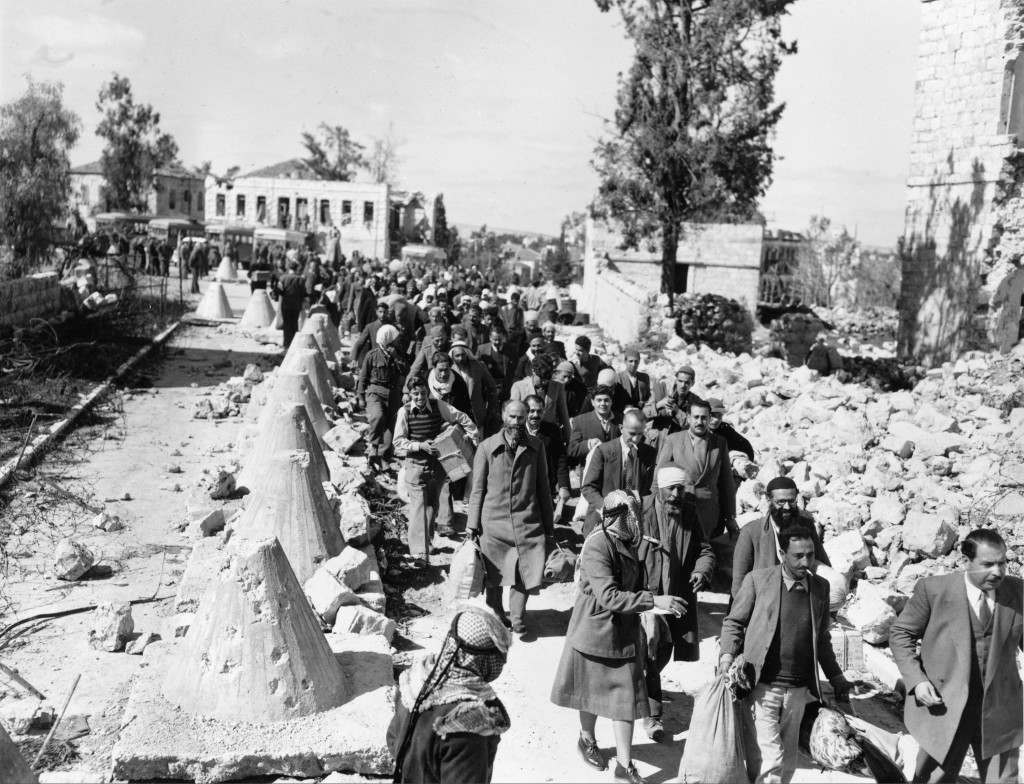 Arab civilians, released by Jews under a prisoner exchange agreement, walk through a debris-flanked no-mans-land road as they return to Arab territory in Jerusalem, March 8, 1949. The Israel-Jordan Armistice Agreement provided for the exchange of Arab civilian prisoners and about 800 Jewish prisoners of war. (AP Photo/Ali Hassan Abu Zarur) Ref #: PA.8658443  Date: 08/03/1949
