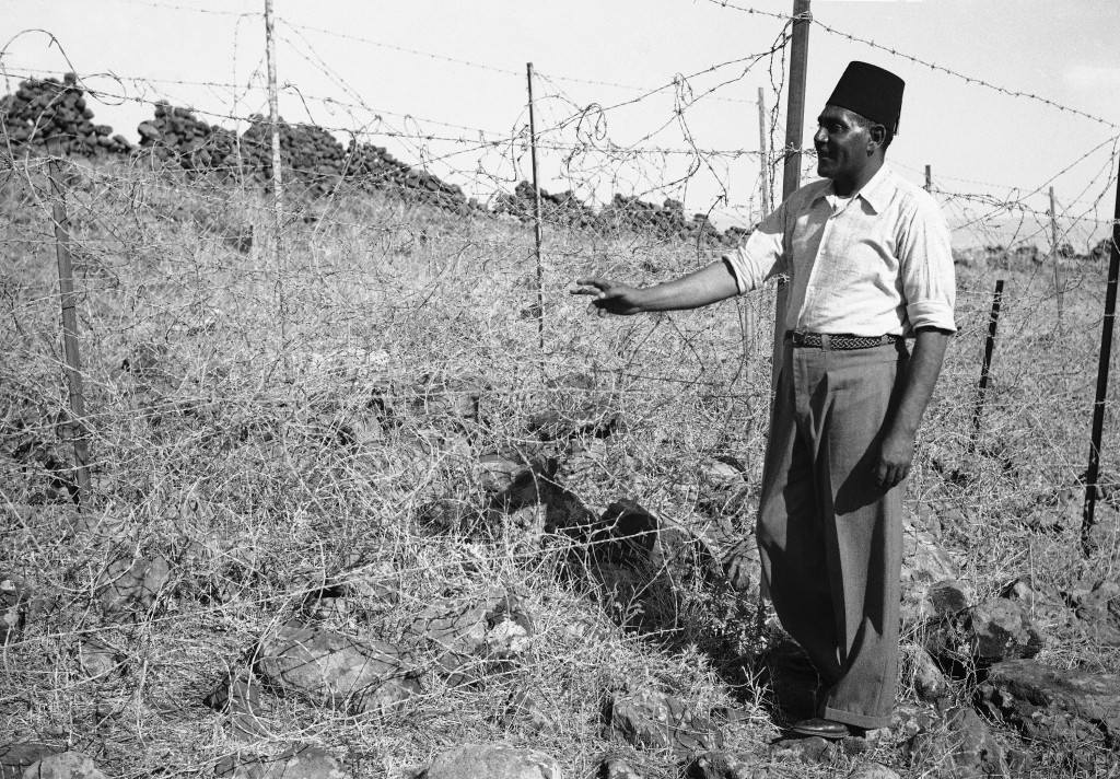 An Arab stands beside a section of Â“TegartÂ’s Iron wallÂ” in Israel in 1938, erected by Sir Charles Tegart to keep marauding Arabs out of Palestine. The fence, three strains of barbed wire on angular iron supports. Stretches for 60 miles on the Syria-Lebanon borders and cost $ 500,000. (AP Photo/James Mills ) Ref #: PA.8988877  Date: 03/10/1938