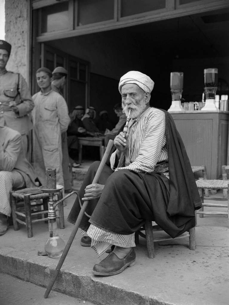 A “Hajj -” an Arab who has been to Mecca and who is looked up by the ordinary Arab in Palestine. Here he is smoking his "hubbly bubbly" a tobacco smoke cooled by water in the jar in Jerusalem, July 17, 1947. (AP Photo/Pringle) Ref #: PA.8996271  Date: 17/07/1947