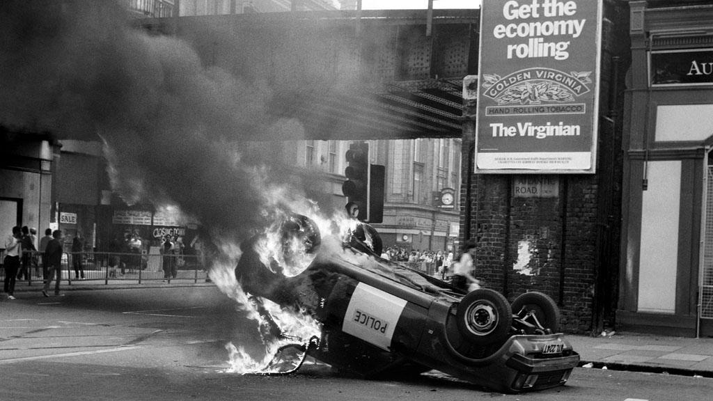 A police car blazes at the corner of Atlantic Road and Brixton Road, Brixton, South London in a fresh and brief outbreak of violence.