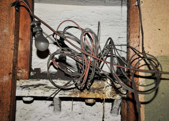 EMBARGOED TO 0001 AUGUST 7. A view of an old light bulb and wires inside the former Brompton Road tube station, a disused station on the Piccadilly line between South Kensington and Knightsbridge which is owned by the Ministry of Defence and which has been put on the property market.