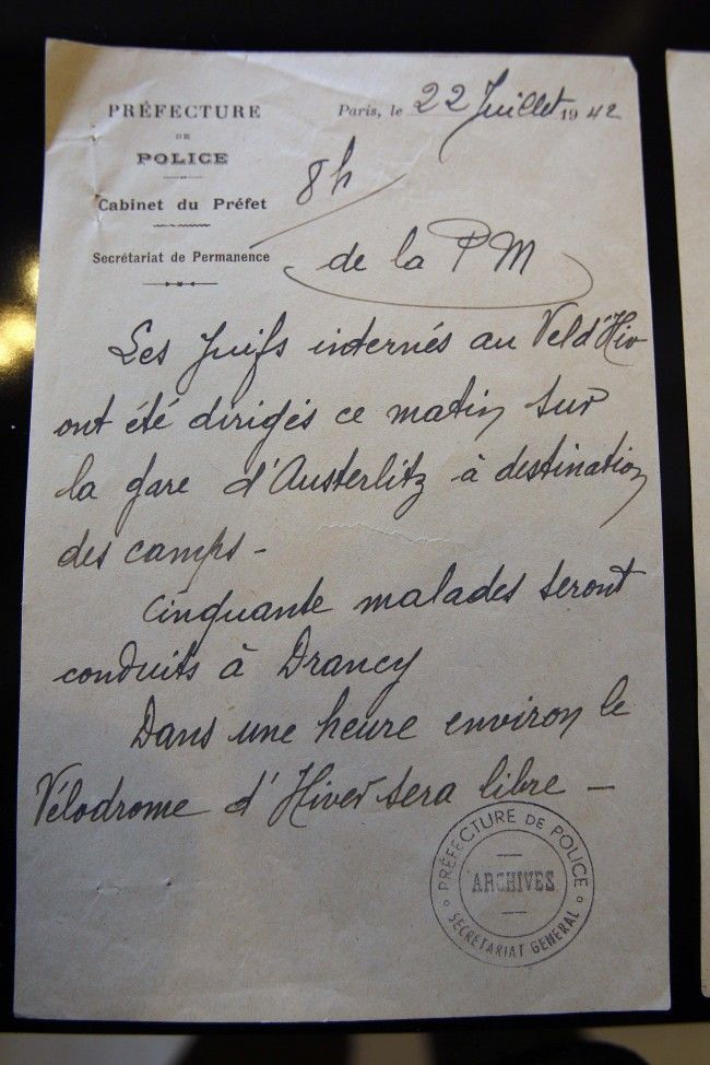 In this photo taken Monday, July 16, 2012 a letter reading "The Jews held at the Vel d'Hiv were sent to the Austerlitz train station this morning for deportation to the camps. Fifty sick people will be sent to Drancy. In about one hour the Winter Velodrome will be available" and coming from the Archives of Paris Police Prefecture is presented for an exhibition of French archives on Shoah in Paris. The chilling archives of the biggest World War II deportation of French Jews are being opened up to public view for the first time. It coincides with the 70th anniversary of the Vel' d'Hiv roundup by Paris police of some 13,000 Jews over two days who were then sent to Auschwitz death camp. Photos, signatures and records of personal possessions from many of the victims are on display at a Paris district town hall. (AP Photo/Remy de la Mauviniere)