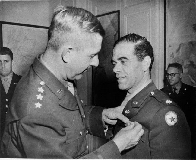 Lt. Gen. Jacob L. Devers, commander of U.S. forces in the European theater of operations, decorates Lt. Col. Frank Capra, former movie irector in Hollywood, now in the Signal Corps with the Legion of Merit Award, Nov. 29, 1943. Location unknown. (AP Photo) 