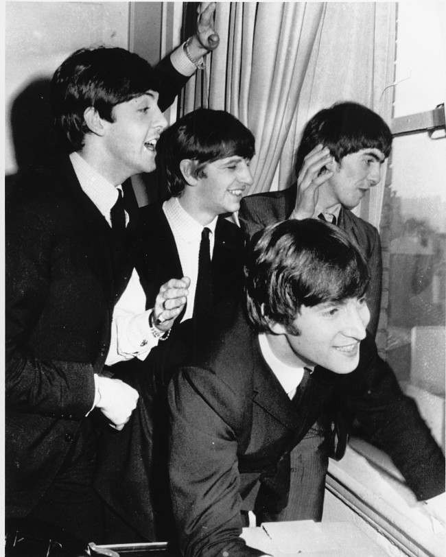 The Beatles wave to fans assembled below their Plaza Hotel window after they arrived in New York City on Feb. 7, 1964 for a short tour of the United States. From left to right are, Paul McCartney, Ringo Starr, John Lennon, and George Harrison. (AP Photo) 