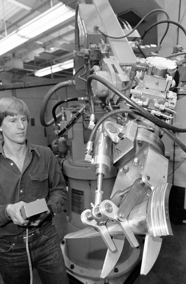 Mark Cutkowsky, a research assistant in the newly-formed Robotics Institute at Carnegie-Mellon University, controls a computer which operates a robot involved in machining turbine blades from raw metal in Pittsburgh, Nov. 29, 1980. The robot is part of a major research project underway that hopes to come up with robot systems that can be applied to a "factory of the future". 