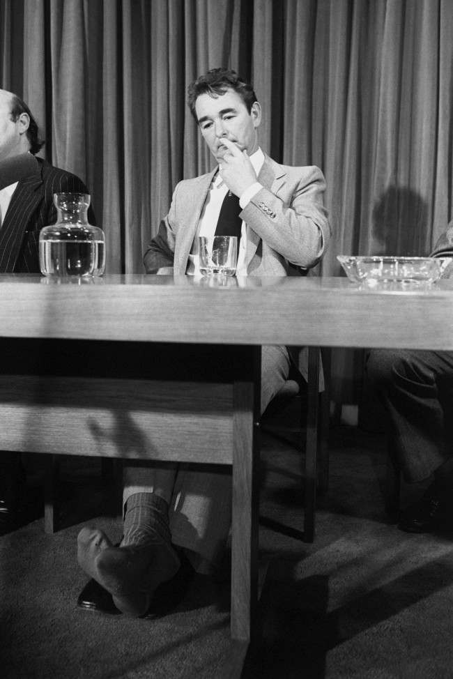 Nottingham Forest Manager Brian Clough, who has taken of his shoes and is showing a hole in his socks, listens during a lunch held by the All Party Football Committee of the House of Commons to talk about problems of violence on the terraces. Brian Clough is considering a future career as a Labour Party member. Date: 12/11/1980