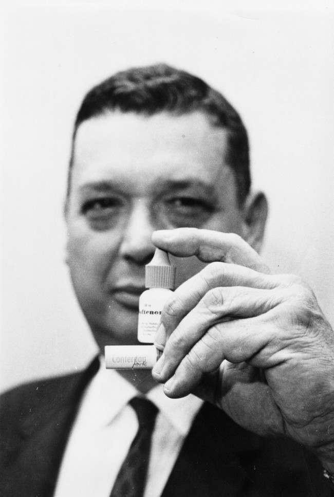 Dr. George James, acting New York City health commissioner, holds containers of the drug Thalidomide, blamed for recent births of deformed children. He said the containers were brought in by persons who read about the drug. James said one, under the trade name Soltenon, was purchased in Ireland, while the other, called Contergan, was bought in West Germany.  Date: 27/07/1962