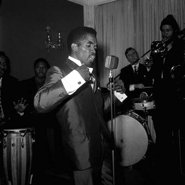 : It's the Blue Beat style as demonstrated by Prince Buster (25) at a reception at the May Fair hotel in London. Blue Beat music is based on a West Indian blues style known as 'Ska Blues'. Buster is here for radio and TV appearances and has brought a Blue Beat hat (a trilby) as gift for Prince Charles. Date: 27/02/1964