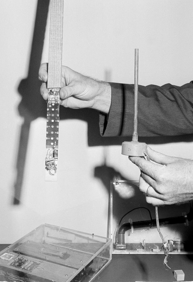 A State Department security person holds one of the more than 40 microphones found in the American Embassy in Moscow when walls of the building were torn down in April 1964. On display May 19, 1964 at the State Department in Washington are other listening devices uncovered in other American embassies behind the "Iron Curtain."