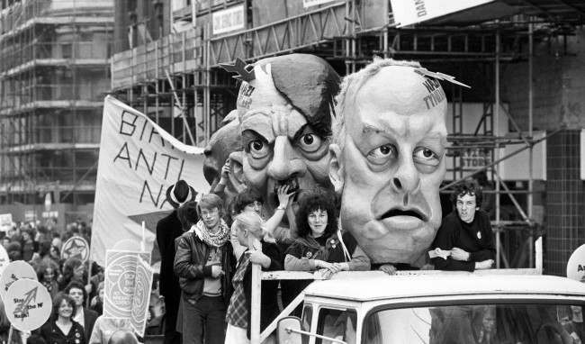 Carnival heads representing National Front leaders John Tyndall (right) and Martin Webster flanking Adolf Hitler on a lorry in a procession of thousands of demonstrators marching from Trafalgar Square to Victoria Park, Hackney, as part of a "Carnival Against the Nazis" organised jointly by the Anti-Nazi League an Rock Against Racism.
