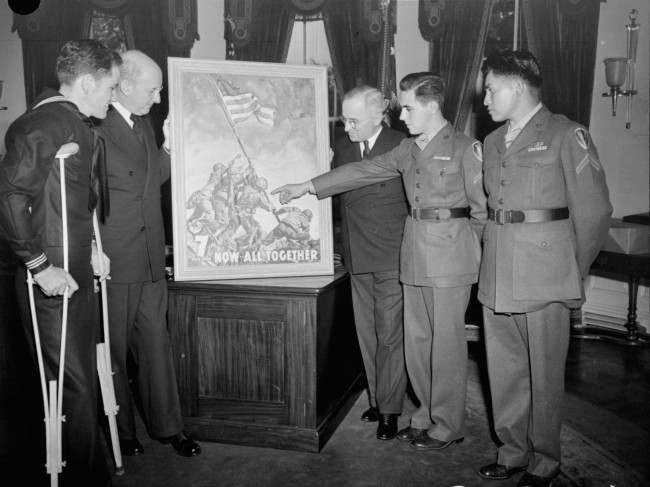 With the three survivors of the famed Mt. Suribachi flag-raising incident as his guests, President Truman gets the first of the new 7th war loan posters, based on Joe Rosenthal's epic Iwo Jima photograph, at the White House, April 20, 1945. Left to right: John H. Bradley, of Appleton, Wisconsin; Secretary of the Treasury Henry Morgenthau, obscured; President Truman; Pfc. Rene A. Gagnon of Manchester, N.H.; Pfc. Ira H. Hayes, Bapchule, Az.