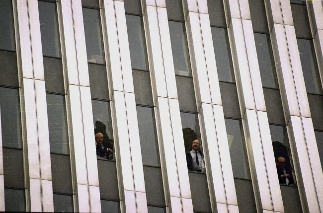 Workers peer through broken windows of the World Trade Center in New York, Feb. 26, 1993, after an explosion in an underground garage rocked the twin towers complex. Heavy smoke, caused by underground fires, was reported throughout the buildings, causing the evacuation of the buildings.