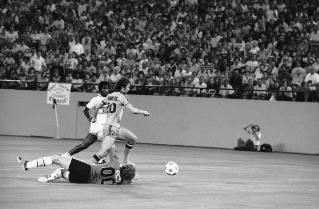 Detroit Express' Trevor Francis (20) breaks past Ft. Lauderdale Strikers' goalie Ian Turner (00), on the ground, with Strikers' Colin Fowles chasing him in the first half of second round of the NASL playoff in Pontiac Silverdome, Aug. 16, 1978 in Pontiac. Francis was tripped up by Turner's arm and lost control of the ball. (AP Photo) Date: 16/08/1978