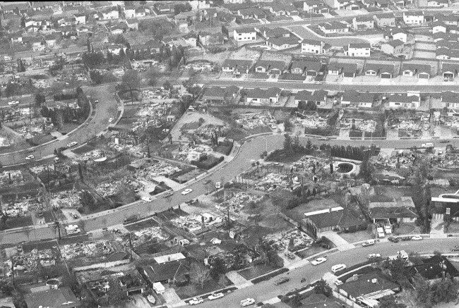 This aerial view shows charred rubble that marks remains of rows of homes destroyed by massive wild fires in north San Bernardino, Ca., Tuesday morning Nov. 25, 1980. Some homes were left virtually untouched by the flames, upper and lower right, but row after row of other homes, numbering hundreds, burned to the ground in the fire that started Monday. 