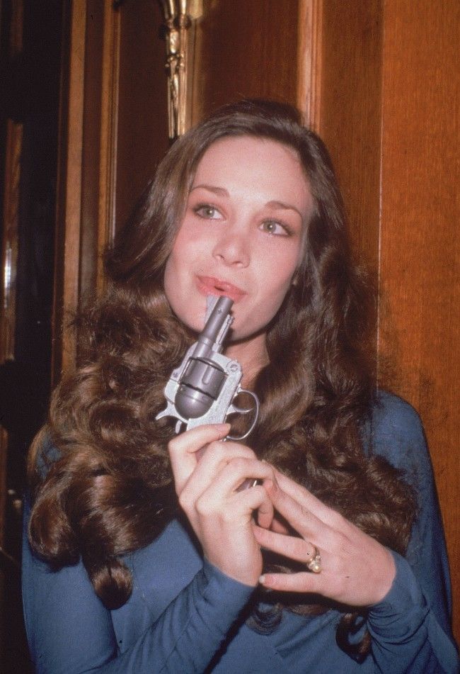 Actress Mary Crosby poses jokingly with a gun during a party in Los Angeles, on November 21, 1980. In the popular TV show Dallas