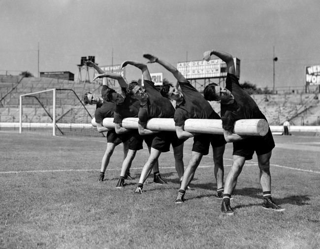 Members of the Chelsea team stretch while holding a 125lbs tree log during training. 100-Archive-g1097-6 Ref #: PA.10651138  Date: 11/08/1953