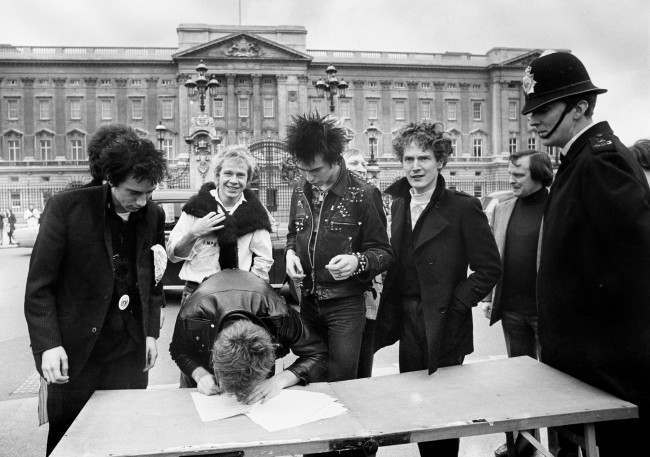  The group Sex Pistols, signing a new recording contract with A&M Records outside Buckingham Palace in London, (l/r) Johnny Rotten, Steve Jones, Paul Cook, new bass player Sid Vicious and the group's manager Malcolm McLaren