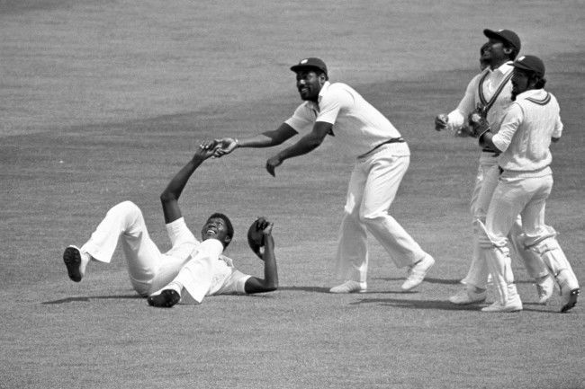 Joel Garner (on ground) gets the congratulations of Viv Richards after taking the catch - off Michael Holding's bowling - which dismissed Alan Knott for nine in England's first innings in the second Cornhill Test match at Lord's . Other West Indian players including wicket-keeper Deryck Murray (wearing pads) celebrate Knott's departure.