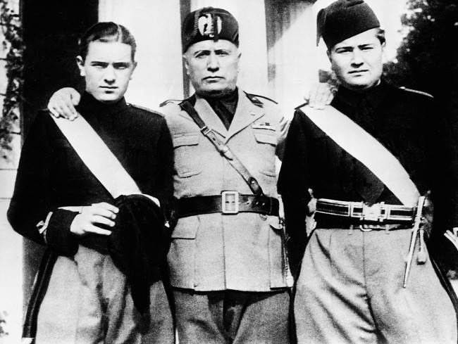 Italy's Premier Benito Mussolini, center, stands with an arm over the shoulders of his two sons, Bruno, left, and Vittorio during the young Fascists' Festival in Rome, Italy, March 14, 1935