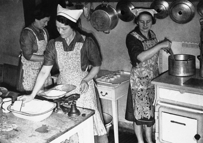 Voluntary workers in the communal kitchen preparing meals, some of which will be eaten by employees in nearby factories in London on Sept. 17, 1941. Others are taken in a mobile canteen to crippled, aged and homeless folk. The canteen normally operates during enemy raids. It is sent around on mercy errands to feed the poor and infirm during the lull in the blitz.