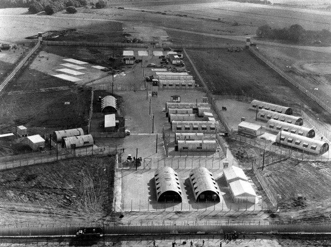 This former airfield is now the internment camp for IRA detainees. The hutments now have central heating and other modern amenities. The camp is called Long Kesh. The airfield was built 30 years ago and used by bombers taking off for Germany. * 