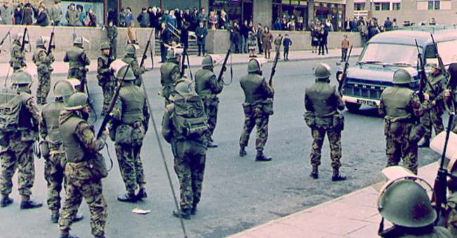 BELFAST IRA CLASHES - British troops straddle a main road near the Catholic Unity flats in Belfast, Northern Ireland, during a lull in the recent current wave of disorders which had flared up in a show of strength by a breakaway group of the Irish Republican Army earlier in the week. Club wielding republican extremists had forcefully halted traffic during the funerals of catholic riot victims. (AP-Photo/Peter Kemp) 02/11/1971