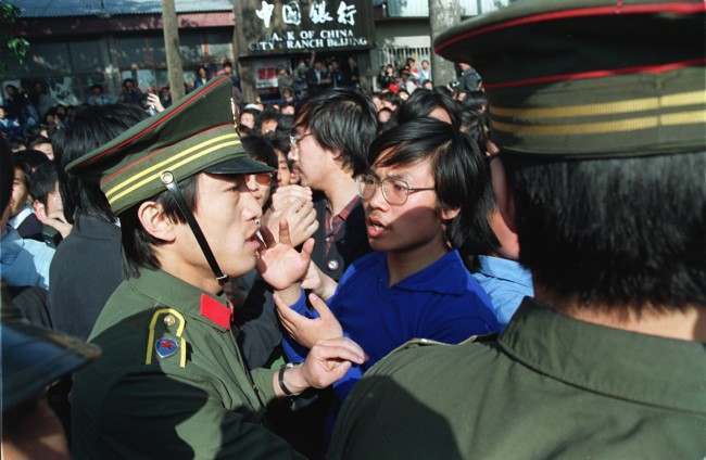 A Beijing University student leader argues with a policeman about the students' right to march as they are told not to march when emerging from their campus. Students from more than forty universities march to Tiananmen Square in protest of the April 26 editorial in the Communist Party newspaper despite warnings of violent suppression.