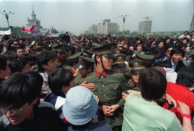 Calling for freedom and democracy, demonstrating students surround policemen near Tiananmen Square in Beijing, China, Thursday afternoon on May 4, 1989. Approximately 100,000 students and workers marched toward the square demanding democratic reforms. (AP Photo/Sadayuki Mikami)
