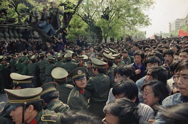 Students demonstrators scuffle with police as they try to break the guard line to march to the Tiananmen Square on Thursday, April 27, 1989 in Beijing. (AP Photo/Sadayuki Mikami)