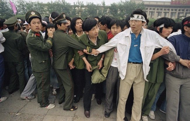 Students and police link area to keep crowd of people, many of the relatives of strikers, from Tiananmen Square, where students have been on hunger strike since Saturday, Thursday, May 18, 1989, Beijing, China. (AP Photo/Sadayuki Mikami)