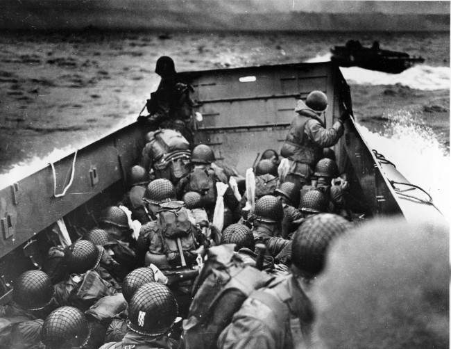 A U.S. Coast Guard landing barge, tightly packed with helmeted soldiers, approaches the shore at Normandy, France, during initial Allied landing operations, June 6, 1944. These barges ride back and forth across the English Channel, bringing wave after wave of reinforcement troops to the Allied beachheads. (AP Photo)