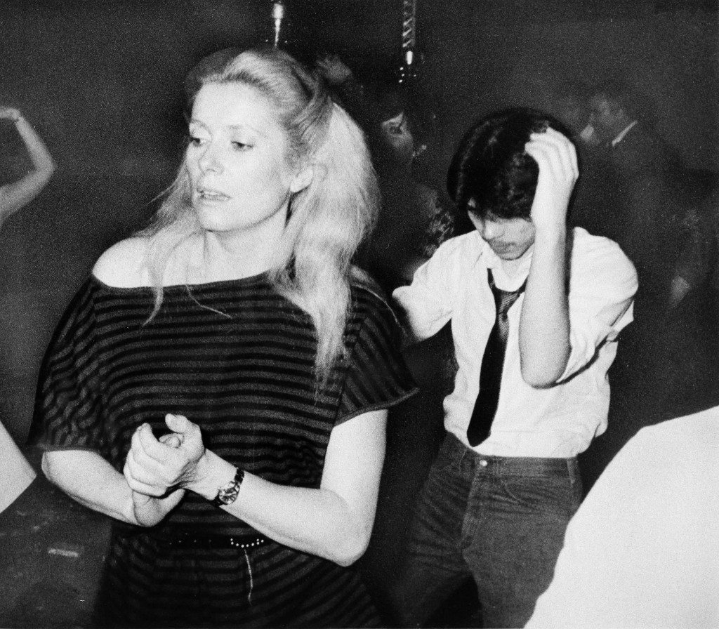 Actress Catherine Deneuve dances at New York disco, Studio 54, Feb. 27, 1979. Man at right is unidentified. (AP Photo)