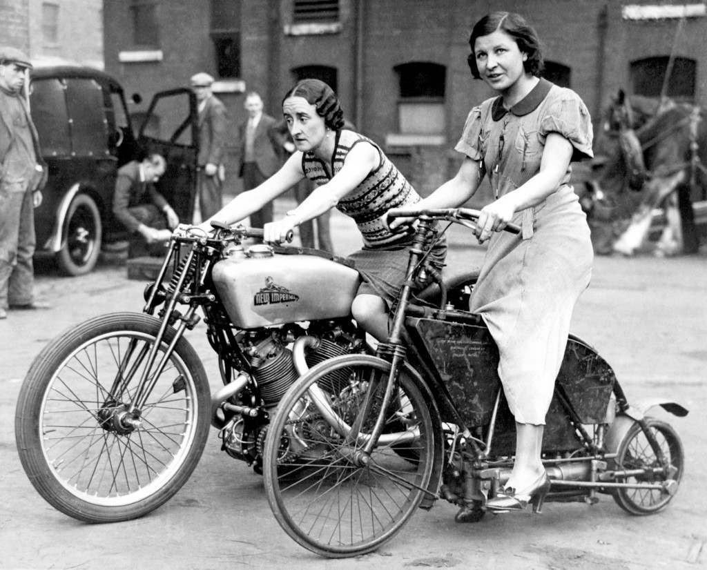 Two ladies astride an 1895 Crank Drive Motorcycle (r) and a 500 New Imperial Twin (l), which has reached 114 mph at Brooklands