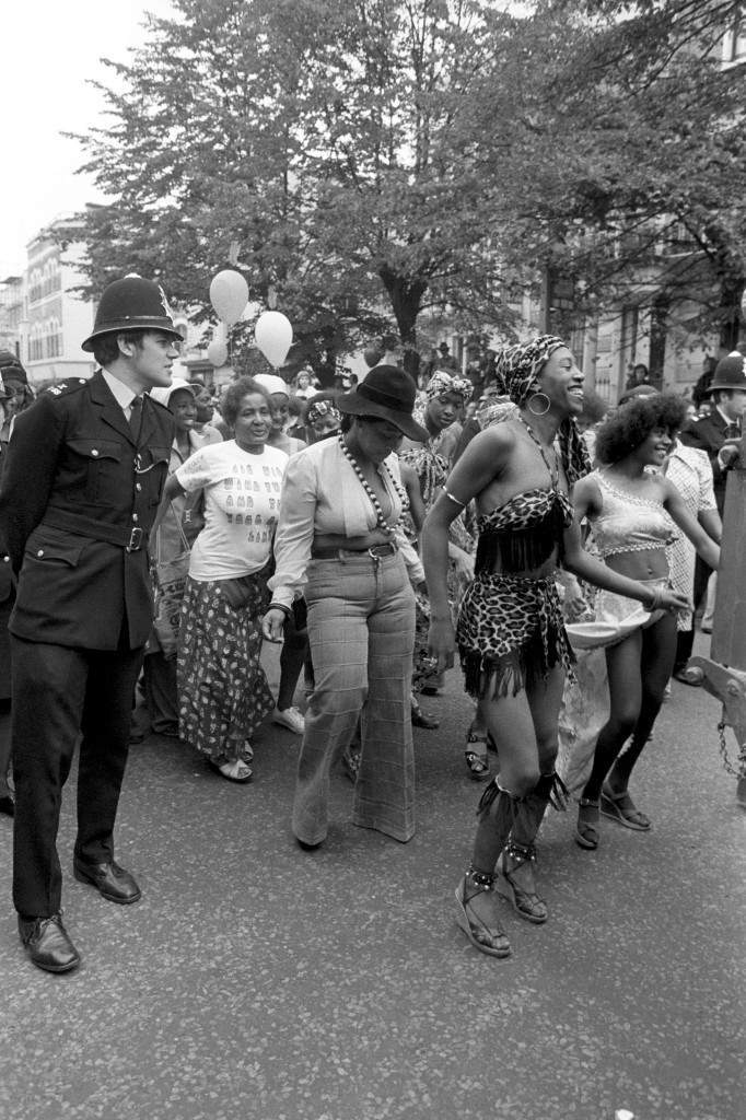 Watched by a policeman some of the carnival go-go dancers find the beat as they follow a steel band float in the eleventh Notting Hill Carnival, which today entered its second and final day at the West London district. Ref #: PA.7694381  Date: 30/08/1976