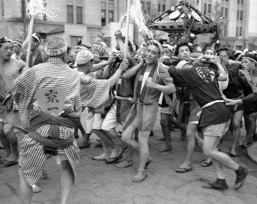 These excited young men are taking part in a festival in the Konda district of the city of Tokyo on April 7, 1949, sponsored by a small restaurant owner in the locality (who also had all the concessions cornered). They are carrying the neighborhoodÂs shrine on their shoulders, all the time jumping up and down and chanting. (AP Photo/Charles P. Gorry) Ref #: PA.11400209 