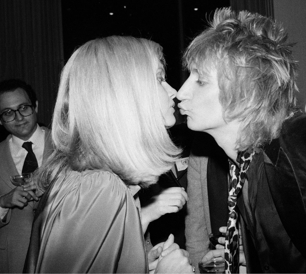 Rock performers Rod Stewart, right, and Olivia Newton John kiss during a party at the United Nations following a taping of the NBC-TV special "A Gift of Song: The Music for UNICEF Concert" in New York City, Jan. 10, 1979. (AP Photo) Ref #: PA.2660079  Date: 10/01/1979