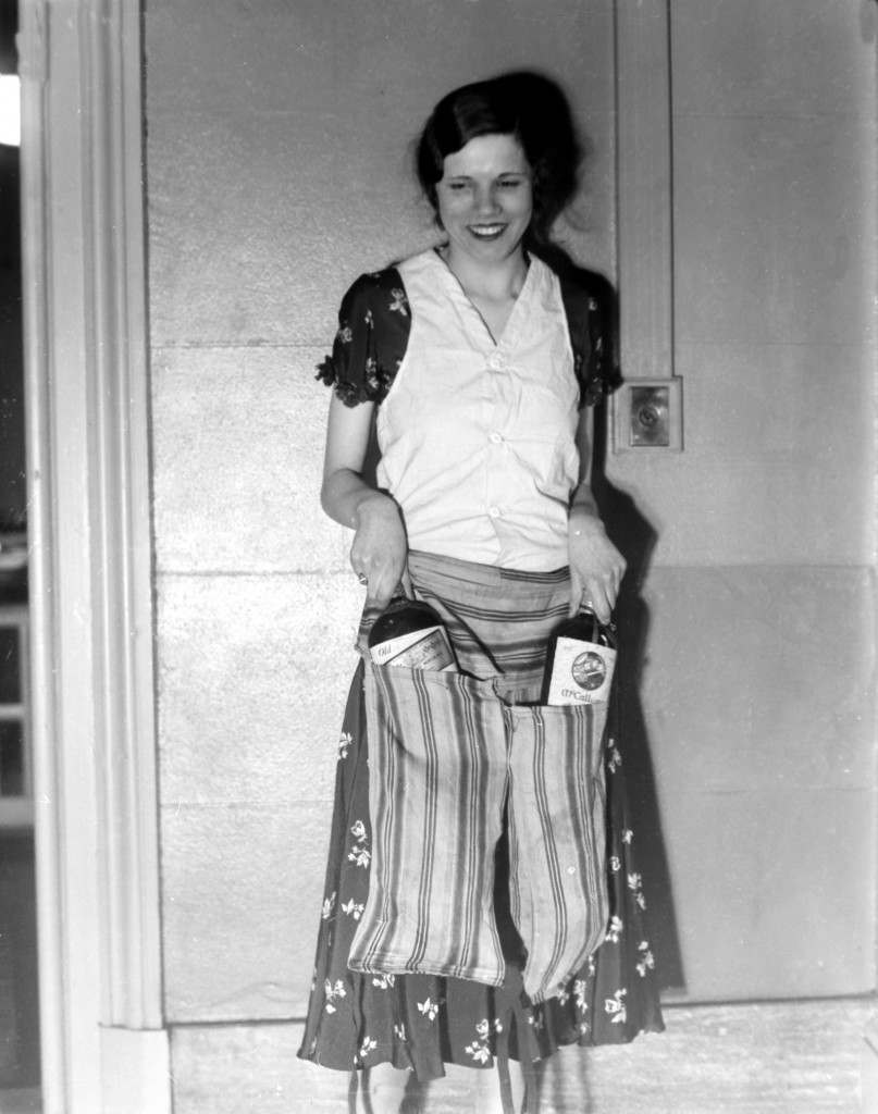 Estelle Zemon shows the vest and pant-apron used to conceal bottles of alcohol to deceive border guards during the U.S. alcohol prohibition on March 18, 1931. (AP Photo) Ref #: PA.3874951 Date: 18/03/1931 