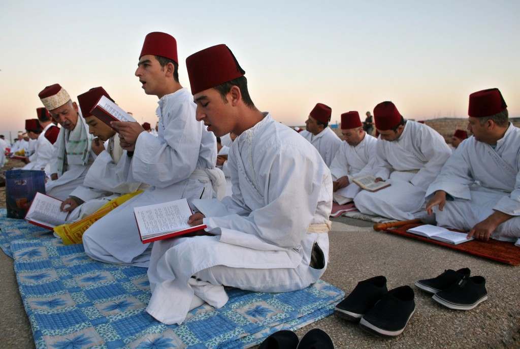 Members of the ancient Samaritan community read from their religious books as they pray during the pilgrimage for the holy day of the Tabernacles or Sukkot at the religion's holiest site on the top of Mount Gerizim near the West Bank town of Nablus, Friday, Oct. 6, 2006. According to tradition, the Samaritans are descendants of Jews who were not deported when the Assyrians conquered Israel in the 8th century B.C. Of the small community of close to 700 people, half live in a village at Mount Gerizim, and the rest in the city of Holon near Tel Aviv. (AP Photo/Kevin Frayer) Ref #: PA.4032870  Date: 06/10/2006