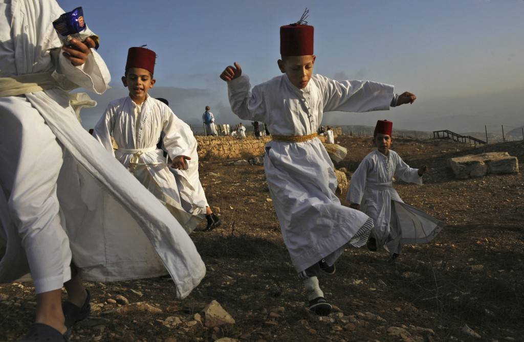 Samaritan children play during the pilgrimage for the holy day of the Tabernacles or Sukkot at the religion's holiest site on the top of Mount Gerizim near the West Bank town of Nablus, early Thursday Oct. 25,2007. According to tradition, the Samaritans are descendants of Jews who were not deported when the Assyrians conquered Israel in the 8th century B.C. Of the small community of close to 700 people, half live in a village at Mount Gerizim, and the rest in the city of Holon near Tel Aviv. (AP Photo/Kevin Frayer) Ref #: PA.5278409  Date: 25/10/2007 