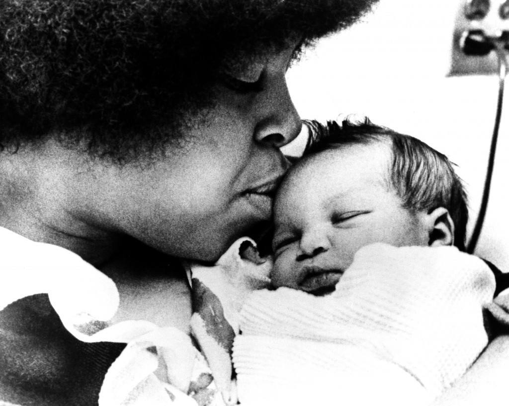 Adrienne Foreman, wife of unbeaten heavyweight boxer George Foreman, bestows a kiss on her three-day old daughter, Michi, in the hospital in Minneapolis, Jan. 8, 1973. Foreman is in training in Jamaica for his January 22 fight against Joe Frazier. Mrs. Foreman is from Minneapolis and her husband will not see the child until after the fight. Mother and child are doing fine. (AP Photo) Ref #: PA.8561542  Date: 08/01/1973