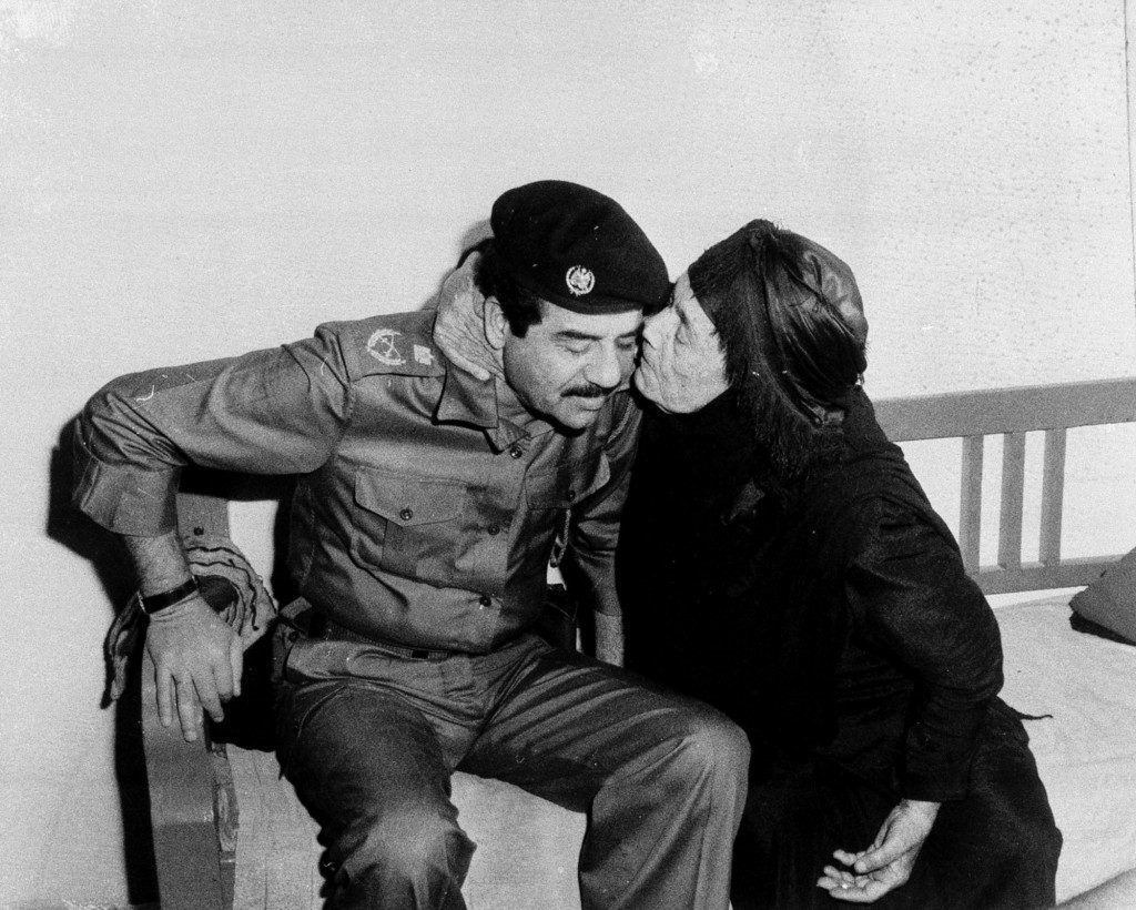 Iraqi President Saddam Hussein receives a kiss from the mother of an Iraqi soldier killed at the front during the war with Iran, in this Nov. 10, 1980 photo. (AP Photo) Ref #: PA.8645692  Date: 10/11/1980